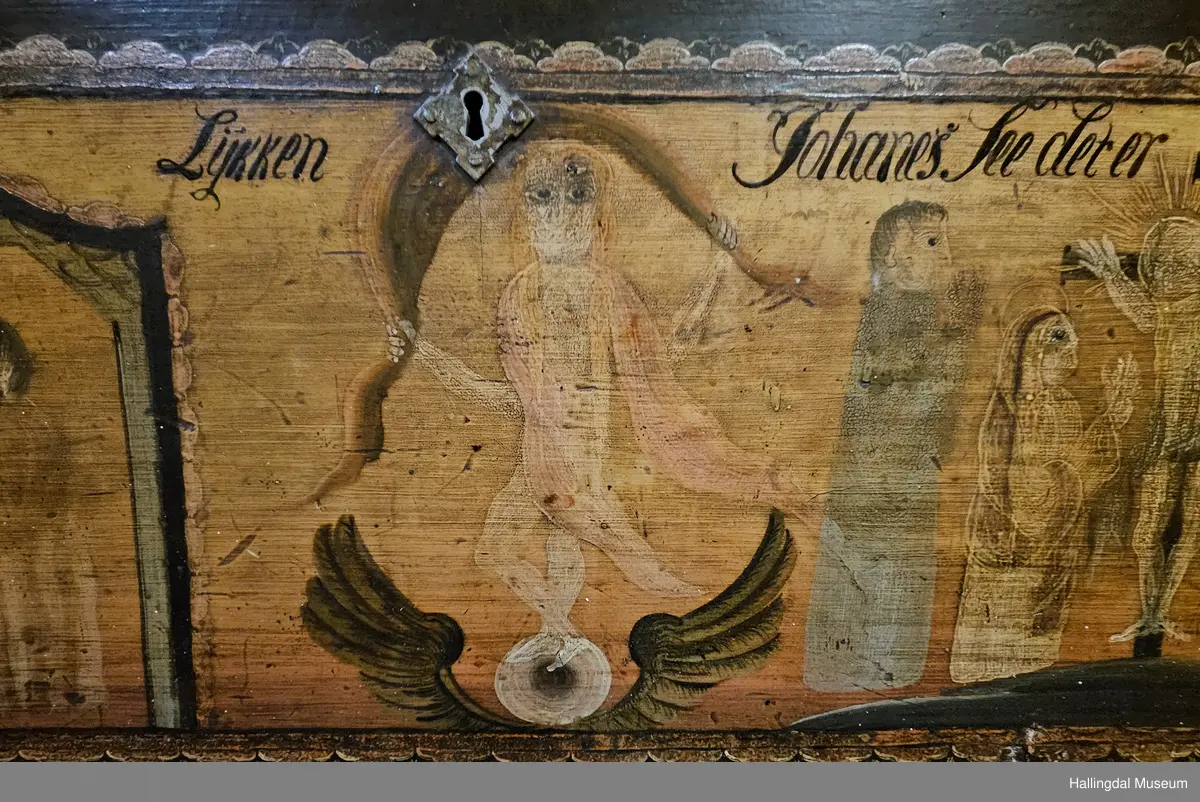 Skatoll med 3 like store skuffer pluss en mindre skuff over disse. På sidene av den øverste skuffen er det støtter som kan dras ut til platen som kan legges ned.  Platen er malt med 3 ulike motiv: Til venstre Maria og Josef med Jesusbarnet og 2 esler i stallen. I midten: En engel med rosa sjal som holder over hodet et brunt klede. Engelen står oppå en kule over englevinger. Til høyre: Jesus på korset med 2 damer og 2 menn.  
De 3 nederste skuffene er malt, 4 rosebuketter på hver skuff. Understellet er utskjært, ranke. 
Bak platen er det 6 små skuffer på hver side av et åpent rom.  Oppå skuffene og platen er det et buet skap med 2 hyller og øverst hylle for tallerker eller skjeer. Dørene har utskjærte speil som er rosemalt. Dørene er gråmalt på baksiden.
Bunnfargen på skatollet er mørk grønt og noe er brunrødt.