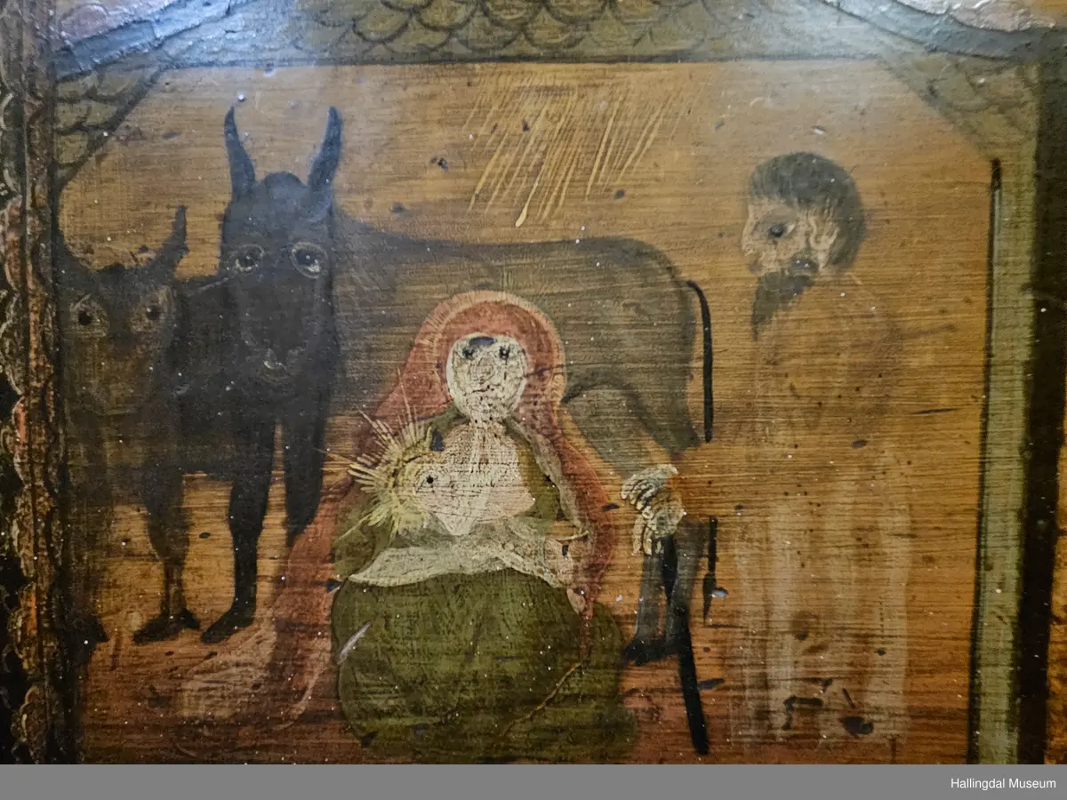 Skatoll med 3 like store skuffer pluss en mindre skuff over disse. På sidene av den øverste skuffen er det støtter som kan dras ut til platen som kan legges ned.  Platen er malt med 3 ulike motiv: Til venstre Maria og Josef med Jesusbarnet og 2 esler i stallen. I midten: En engel med rosa sjal som holder over hodet et brunt klede. Engelen står oppå en kule over englevinger. Til høyre: Jesus på korset med 2 damer og 2 menn.  
De 3 nederste skuffene er malt, 4 rosebuketter på hver skuff. Understellet er utskjært, ranke. 
Bak platen er det 6 små skuffer på hver side av et åpent rom.  Oppå skuffene og platen er det et buet skap med 2 hyller og øverst hylle for tallerker eller skjeer. Dørene har utskjærte speil som er rosemalt. Dørene er gråmalt på baksiden.
Bunnfargen på skatollet er mørk grønt og noe er brunrødt.