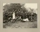 Sjukvårdspersonal vid I 11, Kronobergs hed 1908. I bakgrunden syns några av hyddorna.
Stående i främre ledet: distinktionskorpralerna Gustaf Sjögren och J A Georg Andersson, sjuksköterskan....,,
sergeant Anders Lönn, bataljonsläkare Drougge (bakom dr Drougge till höger: sjukvårdskorpral J A Carlsson (Hamneda)).
Längst till höger indelte sjukvårdssoldaten Jarl.