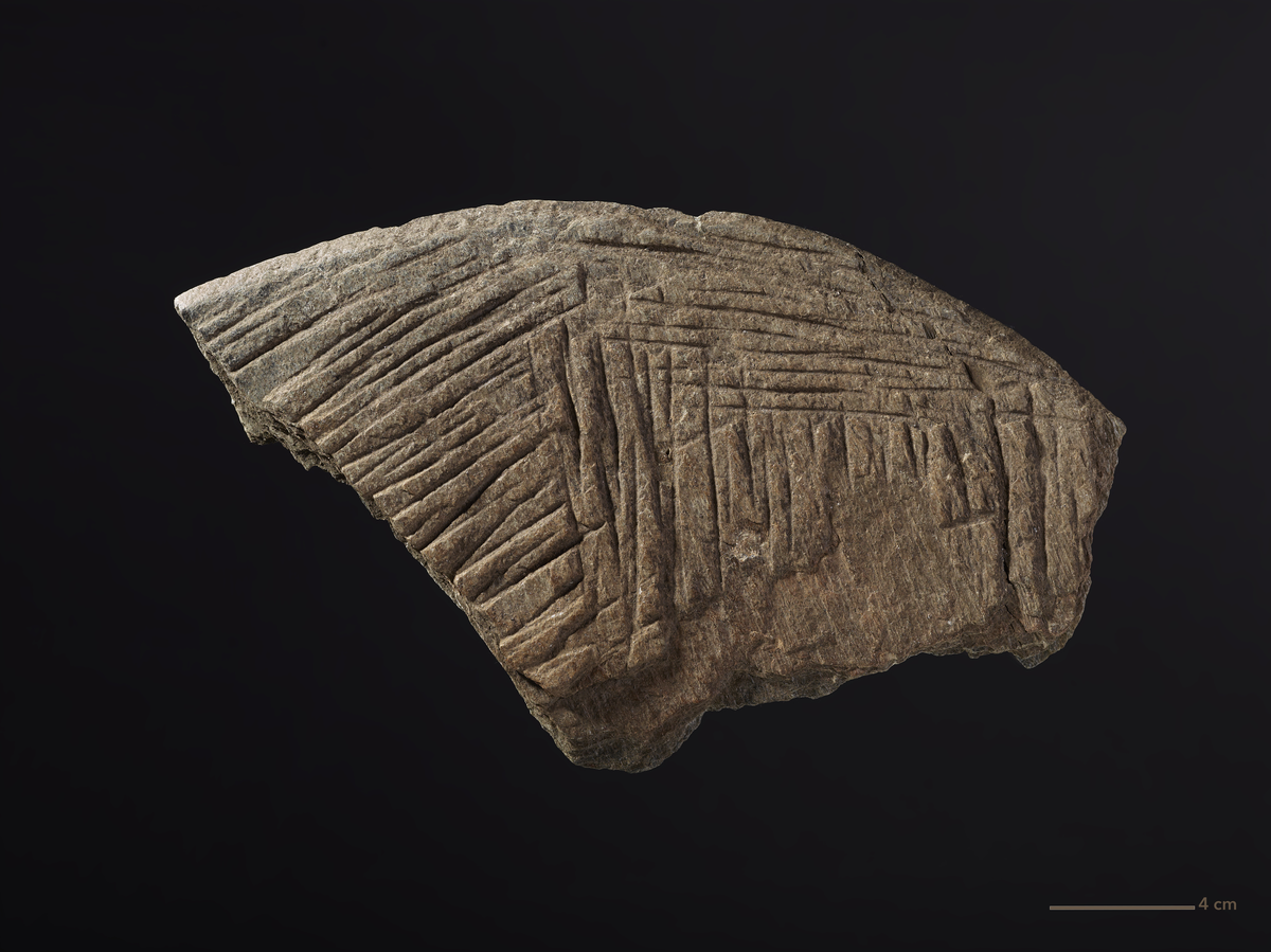 Gjenstand: Kantstykke. Kantstykke av bakstehelle av skifer med rifler på begge sider. Kordel. 20 cm, st. bev. diam. 12 cm.