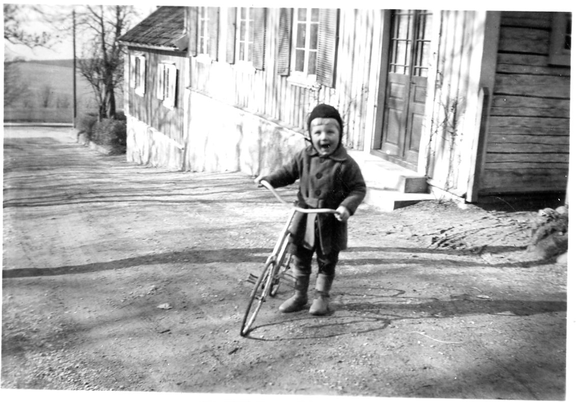 En liten pojke med en cykel, en vårvinterdag.