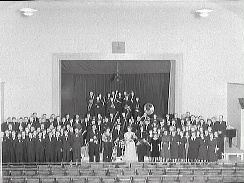 Folkskolan/Rosenfredsskolans aula. Orkester och kvartettsällskapet i Varberg. Från vänster: Karl Ljunggren, Yngve Johansson "Glas Pelle", Gösta Karlsson, Viktor Andersson, Gösta Svensson, Sven Gustavsson, Kubizeck, Nils Olsson, Bertil Olsson "Lången", Albin Broberg, Erik Sörström, Karl Oskar Olsson, Åke Ljunggren, Evert Olsson, Gustav Sörström, Erik Persson, Fritz Svensson, Erik Emanuelsson, Artur Holmström, Alla Pettersson, Ingeborg Eliasson, Göte Karlsson med trumpeten, Sven Karlsson med bastuban. Mitten: Gevert, Ingegerd Andersson, Nils Holmström, Anna-Lisa Åsare, Seiving, Tore Nilsson, Gunnar Andersson, Arne Berglund, Yngve Persson, Bertil Skoglund, Håmark. Från höger: Hildur Johansson, Tyra Ahlström, Martin Andersson, Karl Nilsson, Einar Helin, Oska Bengtsson, Olof Österberg, Fritz Weddig, John H Johansson.