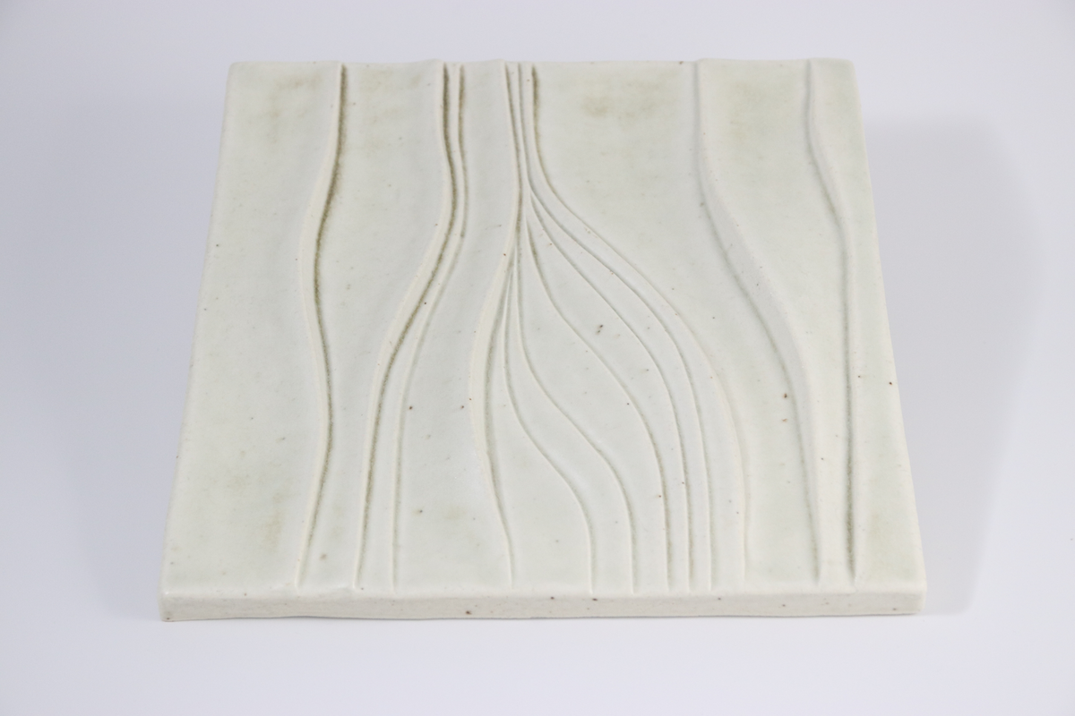 Olle Alberius, väggplatta, kvadratisk med vågigt reliefmönster, kavlat och modellerat stengods i vit glasyr. Rörstrands porslinsfabrik, 1970.