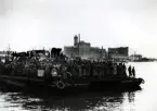 Tysk landstigningsbåt i Kalmar hamn i maj 1945. De baltiska soldaterna i tysk uniform kom från ett brohuvud i Baltikum dit de drivits av Röda armén. När de kom till Kalmar upprättades ett läger på Kullö. Senare fördes de till bl a Eksjö.
