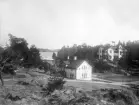 Miljö vid Arkösund vid fotografens besök omkring 1905. På hotellets tak annonseras årtalet 1903, vilket möjligtvis visar att tidens ombyggnad då stått klar. Byggnaden i svackan är Gråbo som fungerade som personalbostad och tvättstuga för hotellets verksamhet.