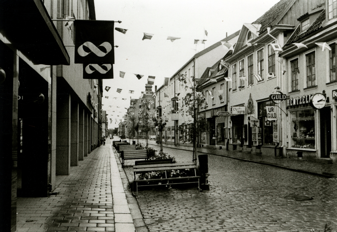 Kvarteret Apotekaren mot Storgatan. Butiker och linor med små flaggor mellan husen.