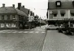 Kvarteret Guldsmeden från Larmtorget. Till vänster kvarteret Blockmakaren. Butiksbyggnader och Storgatan med vimplar.