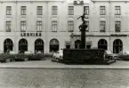 Eoska huset på Larmtorget. Storgatan i förgrunden. Vasabrunnen av Nils Sjögren föreställandes David och Goliat på pelaren.