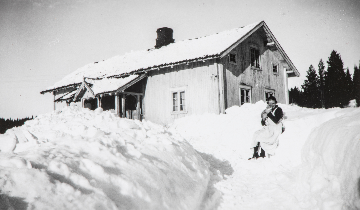 Bilde fra Bergset, vinter og snø. Berthe Nordli med en katt i fanget, ute på gårdstunet.  Karl Johan Nordli var 2 ganger i Amerika. Første gang i 1916, i Montana. Andre gang var fra 1922-1925 da dro han til California, og jobbet på søsterens gård / farm.
Han reiste tilbake til Norge,og giftet seg med Berthe Ophus (fra Løten) i 1926 og kjøpte Bergset som lå i Øståsen i Vang. De var eier av Bergset frem til 1953.