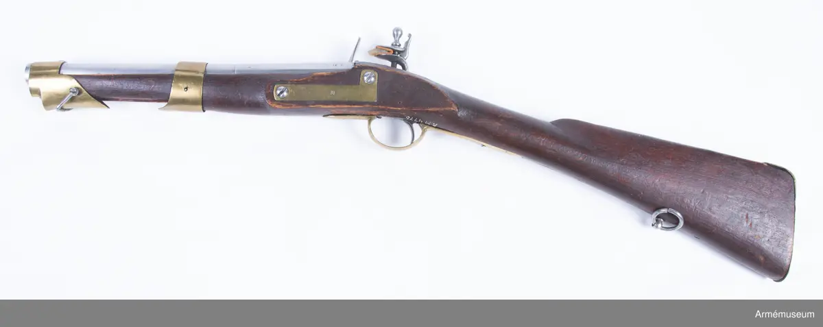 Med flintlås och karbinkolv kallat "karbinpistol" med flintlås. Loppet har 4 refflor. Pipa och lås ursprungligen m/1704. På kammarstycket många otydliga stämplar däribland årtalet 1712. Stämpel på låset med bokstäverna N.B. Beslag av mässing. På undersidan vid varbygelns bakre fot stockmakaremärket P.S.