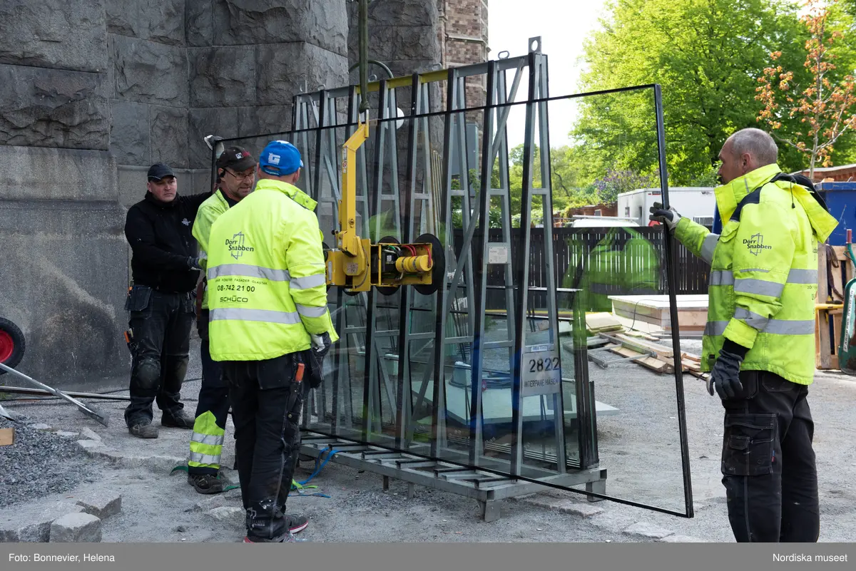 Exteriörer från Nordiska museets västra sida, bakgården, under arbetet med den nya entrén och byggnaden Lusknäppen. Entrén är ritad av Lone-Pia Bach. Konstnären Outi Pieski står för den konstnärliga gestaltningen med konstverket Two Directions, inspirerat av föremål ur museets samiska samlingar. Montering av glaset i utbyggnaden.