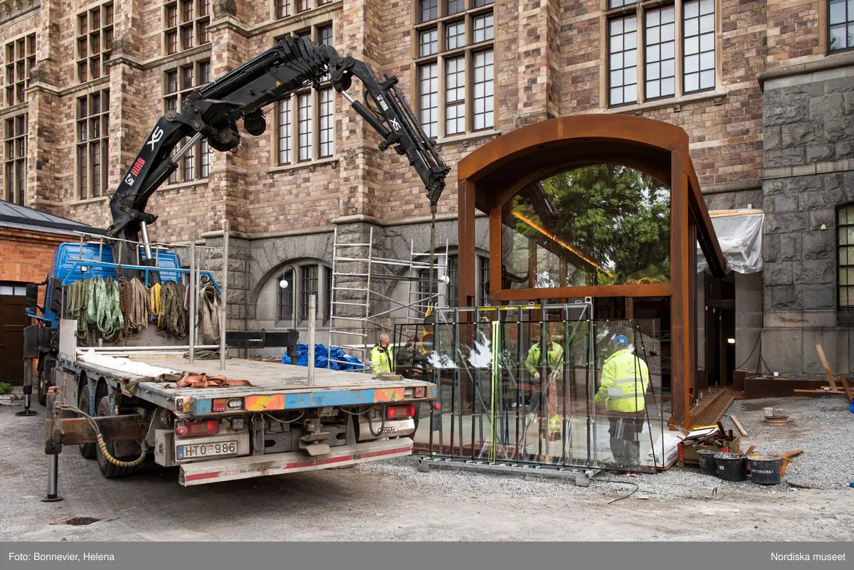 Exteriörer från Nordiska museets västra sida, bakgården, under arbetet med den nya entrén och byggnaden Lusknäppen. Entrén är ritad av Lone-Pia Bach. Konstnären Outi Pieski står för den konstnärliga gestaltningen med konstverket Two Directions, inspirerat av föremål ur museets samiska samlingar. Montering av glaset i utbyggnaden.