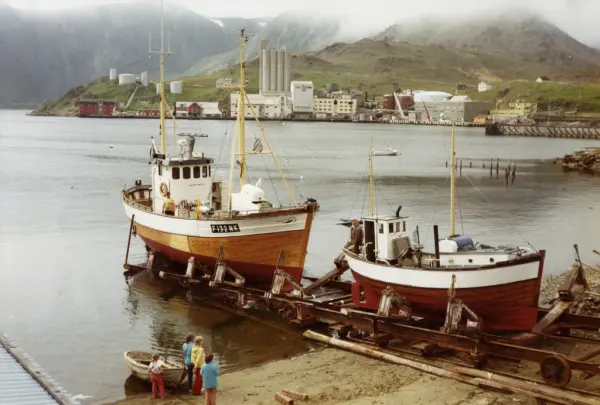 Honningsvåg. To båter på Brødrene Isaksens patentslipp i Storbukt. Flere barn ser på.