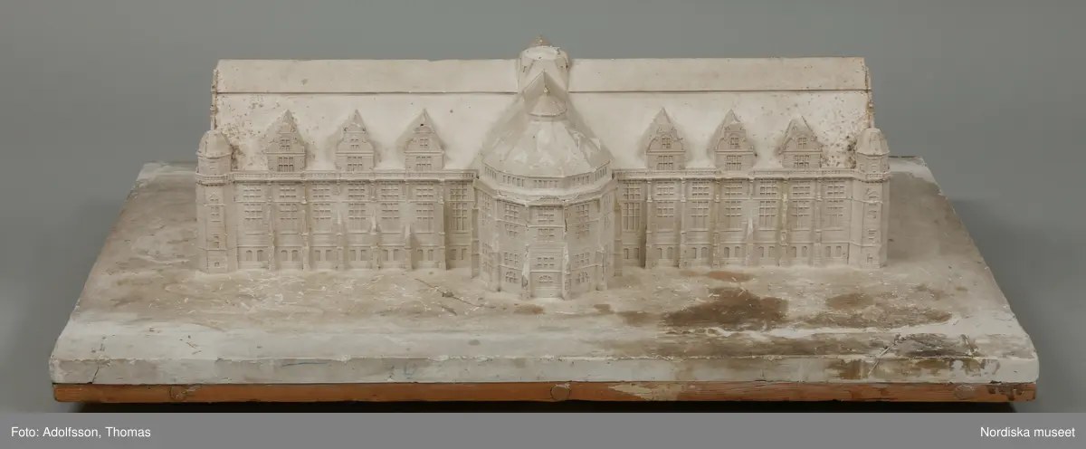 Huvudliggaren:
"Byggnad, modell; Nordiska museets hallbyggnad, gips; trol.gjord för erhållande av byggnadstillstånd; mycket skadad . Från 1891, funnen omärkt på vinden."