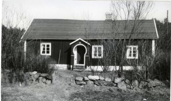 Stuga väster om Åsa med nyckelhålsformad så kallad skunke, dvs liten tresidig förstukvist med sittbänkar längs sidorna. Över öppningen sitter en lyckobringande hästsko.