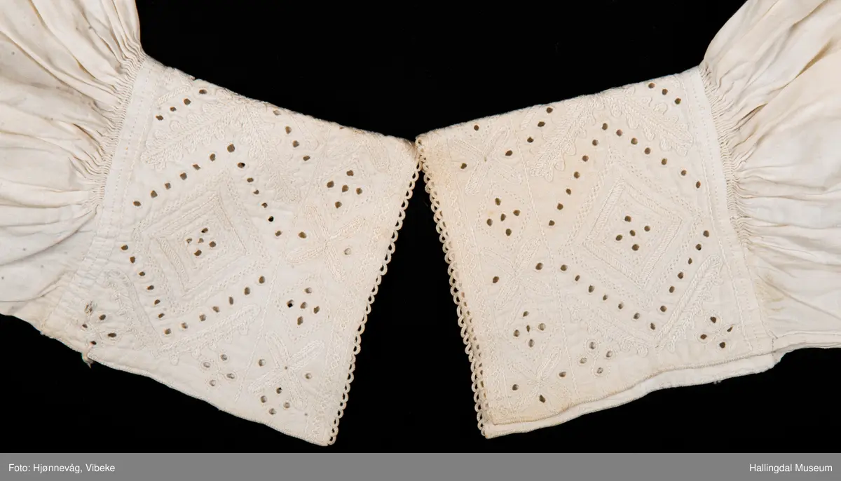 Rynket til halslinning. Kile ved skulder, rynket til halslinning, Erme rett ved skulder, rynket til mansjett. Kile under erme. Broderi i kvitsaum på linninger.