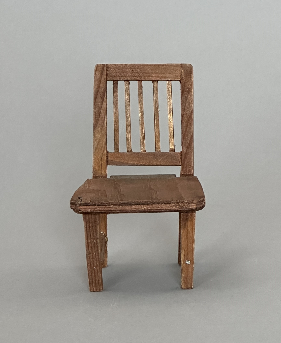 Brunbetsad leksaksstol i trä och plywood.