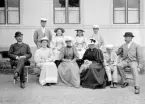 Familjen Reuterswärd med gäster samlade för fotografering vid Västanå i Borensberg. Foto omkring 1895. Familjen hade fast adress i Linköping och disponerade vid tiden Västanå som sommarbostad. Sittande från vänster ser vi överste Wilhelm Reuterswärd, dottern Elin, fotografens fru Louise von Rosen, hustrun Carolina af Robson, sonen Gustaf och kapten Hjalmar Ekström. Stående från vänster ses överstens son Wilhelm, följd av parets gemensamma barn i Eva, Kristina och Olof.