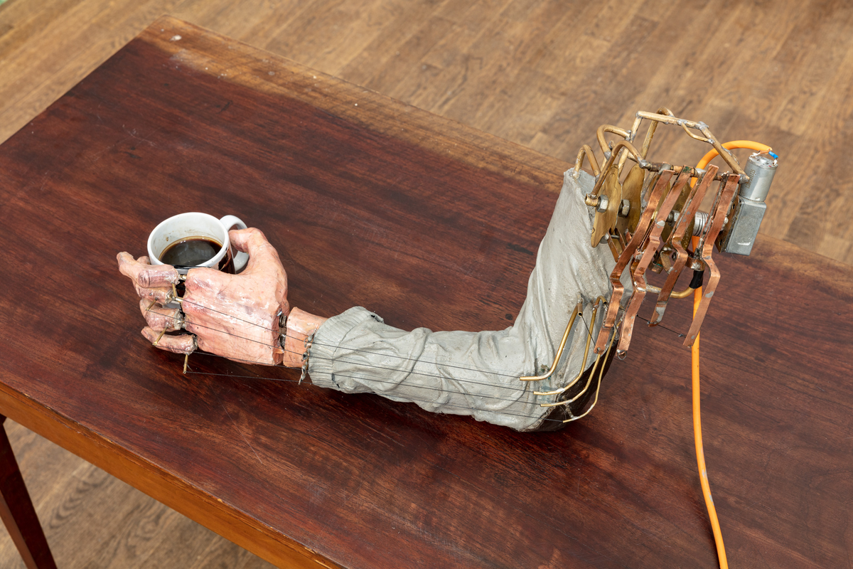 En mekanisk skulptur bestående av en gjuten arm som försiktigt knackar på en kaffekopp som står på ett bord. Ljudet av knackningen förstärks via en piezomikrofon och en förstärkare monterad under bord. Det mekaniska systemet är starkt inspirerat av 1700-talets urverksautomater - med hjälp av en matris av roterande mässings-"kammar" med handskurna spår som översätts till den upprepade rörelsen hos fingrarna. 
Den kroppslösa armen knackar på kaffekoppen upprepade gånger till leda. Om otålighet, autonomi, tristessen och vardagen, kaffet som ett svart hål.