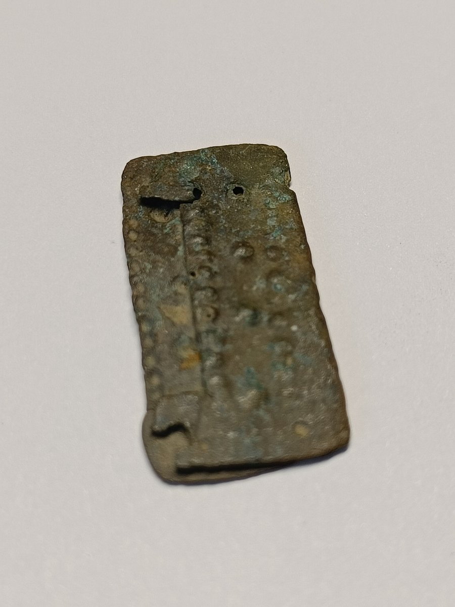 Perledekor langs kantene og i midten av beslaget. 