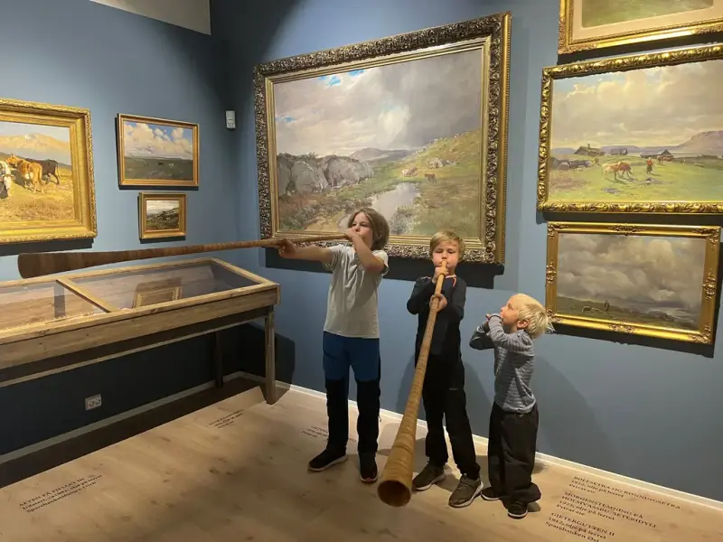 Tre gutter spiller på lur i galleriet 