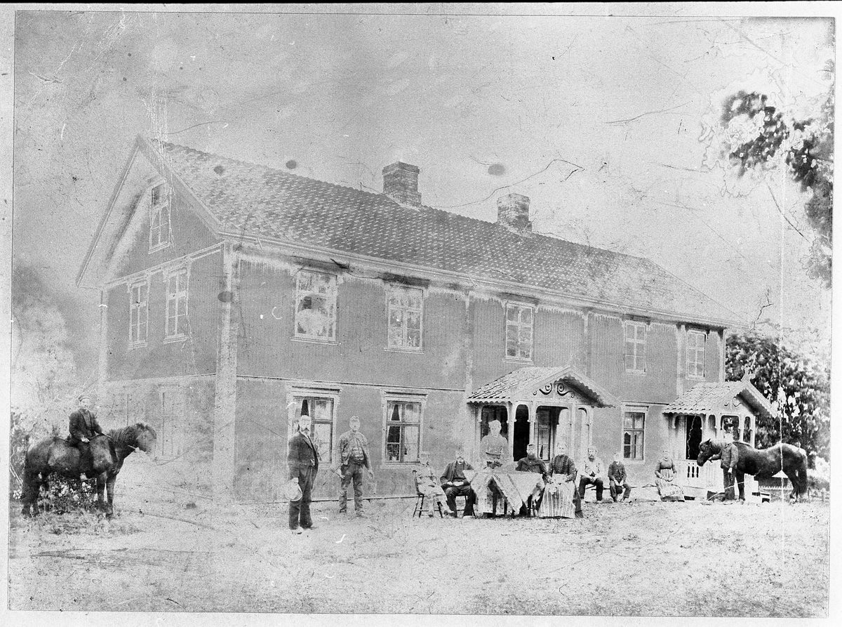 Hovedbygningen på gården Oppegaard Midtre i Totenvika ca. 1894. Personer på bildet er: Laurits Andersen (på hesten), Haaken Gulliksen, August Ødegården, Jenny Oppegaard (g.Aarsby), Johannes Oppegaard, Marie Oppegaard, Ingeborg Marie Oppegaard (f.Langaard), Even Løkkebakken (?), Magnus Løkkebakken, Anne Langaard, Martin Løkkebakken.