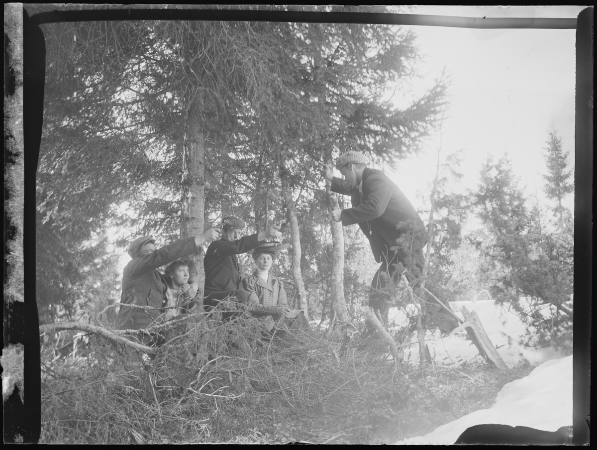 Kvinner og menn spiller teater i skogen med fanger og revolvere. Antatt elver ved Eidsvoll folkehøgskole.