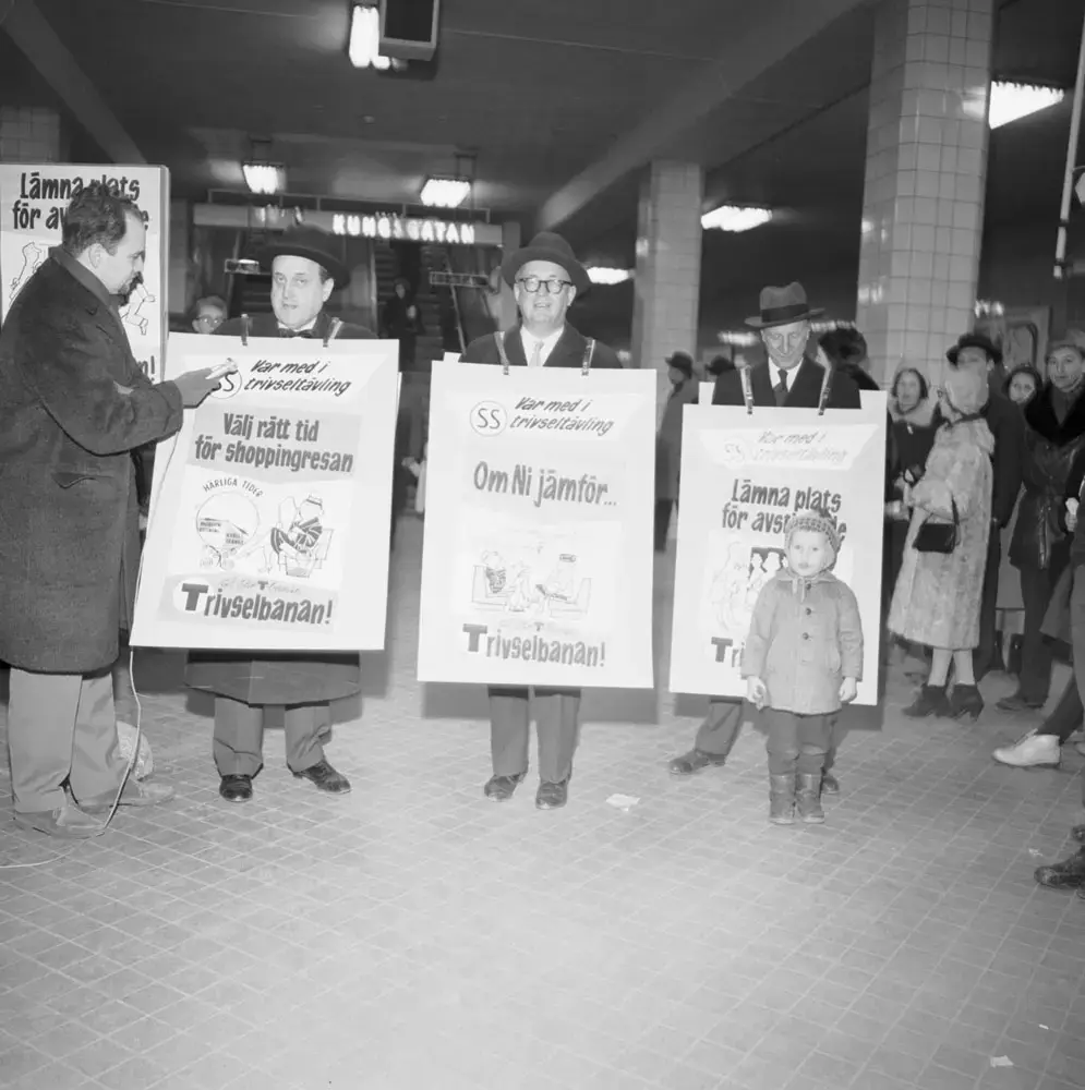 Trivselkampanj ”Så blir tunnelbanan Trivselbanan”. Fr v Vd Hans von Heland, borgarråd Helge Berglund och Trafikdirektör Erik Tengblad som sandwichmän, klädda i affischer om SS trivseltävling.