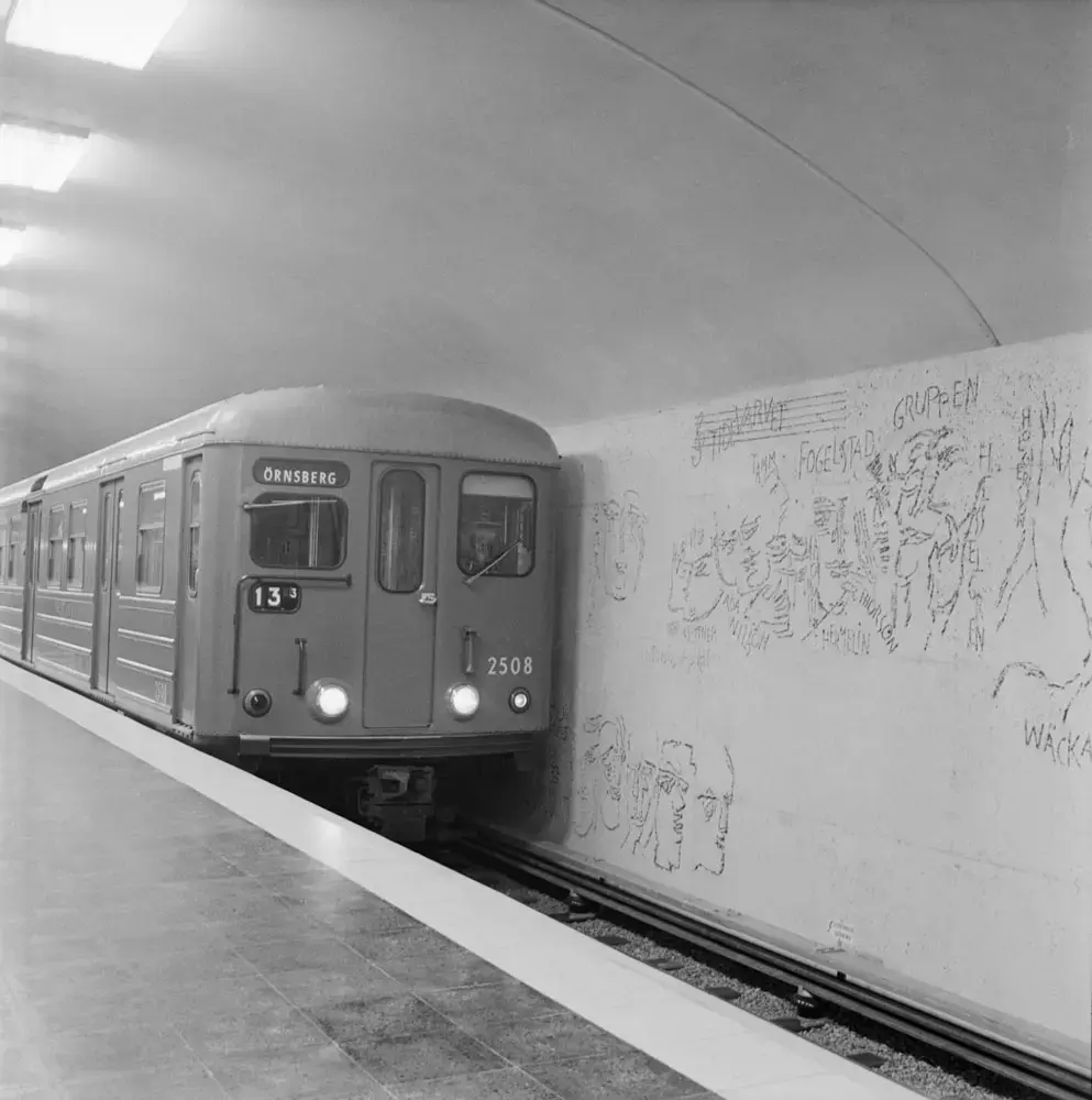 Tunnelbanetåg, C4, vid Östermalmstorg. Till vänster Siri Derkert  konst "Ristningar i naturbetong".