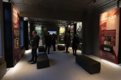 En gruppe mennesker studerer plansjer i utstillingen. 