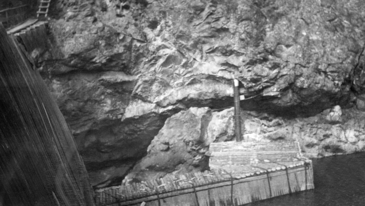 Den påbygde Sølvstudammen i Ågårdselva, fotografert før flommen våren 1931. ildet er antakelig tatt fra en bergkrent på sørsida av vassdraget med kameraet vendt ned mot en del av dammen, der det ser ut til å ha stått ei rekke av tettstilte pæler på motstrøms side og en skråvegg av vertikalstilte planker i vinkel med denne. Mellom denne pælerekka og den bratte bergskrenten på nordsida av innløpet til fossen hadde man lagt et golv av rundtømmer.

Ågårdselva er en del av Glommas vestre løp gjennom daværende Tune kommune i Østfold. Denne elvesrekningen er cirka fem og en halv kilometer lang og renner fra den nordvestre enden av Isnesfjorden (Vestvannet) sørvestover gjennem berglendt terreng mot innsjøen Visterflo. Høydeforskjellen mellom Isnesfjorden og Visterflo er på bortimot 25 meter. Ågårdselva har tre fossefall, det øverste her ved Sølvstu, deretter ved Valbrekke og nederst ved Solli. Denne elvestrekningen ble ikke brukt som fløtingsled lenger da dette fotografiet ble tatt. I perioden 1906-1908 bygde nemlig Fredrikstad Tømmerdirektion i bruk en tømmertunnel gjennom berget fra Svartdal (fra da av også kalt «Toppen») ved Isnesfjorden til Eidet ved Mingevannet. I årene som fulgte ebbet virksomheten ved det en gang så store Sanne og Solli Bruk ut. Likevel hadde man sannsynligvis startet diskusjonen om bygginga av en ny Sølvstudam. Selskapene Borregaards og Hafslunds hadde nemlig gjort inngrep i Glommas østre løp, hovedløpet, som i lavvannsperioder gjorde det svært vanskelig å få tømmer som skulle til bedrifter nedenfor Sarpsfossen via Mingevannet, Isnesfjorden og den nevnte tømmertunnelen til Eidet gjennom det ovenforliggende trange sundet ved Trøsken. Dette forsøkte man å løse ved å heve vannspeilet i Isnesfjorden med en dam som skulle plasseres 10-15 meter ovenfor den eksisterende dammen ved Sølvstufossen.