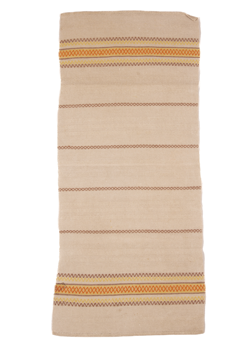 Beige løper med striper i stoffet, og border i endene. Faldet med hullsøm. Stripene er horisontale laget av et sikksakkmønster. Det er brune striper i en symmetrisk mønster langs hele duken, mellom de brune stripene er der tre parallelle horisontale lys beige striper. I hver ende er det en samling av striper i ulike farger som gul, rød og brun. 
