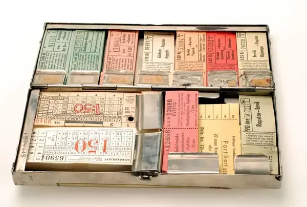 Biljettlåda från Mälaröarnas Omnibuss AB. För små blockbiljetter. Plats finns för 21 biljettblock i 3 fack. Innehåller följande biljetter:
MOAB, kvitto 50 öre, block med ursprungligen 200 bj
MOAB, kvitto 1 kr, block med ursprungligen 200 bj
MOAB, kvitto  25 öre. 1 kr,  1,50, 2,50 (fraktmärken)

MOAB