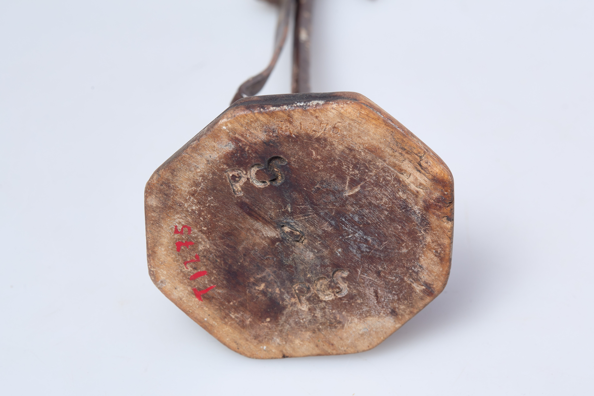 Foten av tre har syv kanter. Holderen er av jern og lyset står i en jernring.