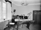 Kvinna sitter i soffa, Uppsala 1946