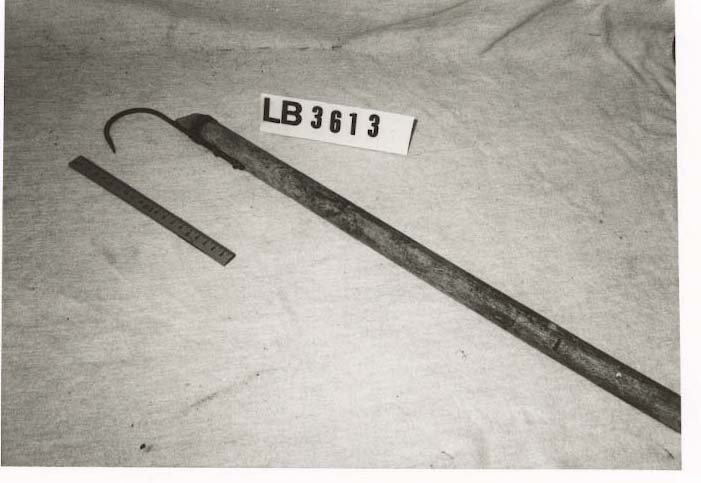 Klepp med treskaft og jernkrok festa til den eine enden med ståltråd.