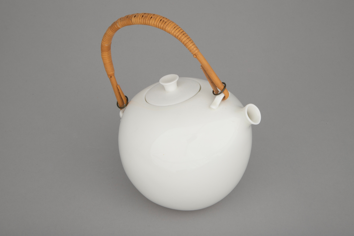 Tekanne med lokk i hvitt benporselen med hvit glasur og flettet rørhank. Kannen har kuleformet korpus uten markert overgang til en kort tut med rund åpning, dannet som en sammensnevring av korpus. Den flettede hanken er festet til to små "ører", den ene mellom tut og lokk og den andre på bakre del av korpus. To små metallringer holder den på plass. Kannen har glatt overflate uten dekor.