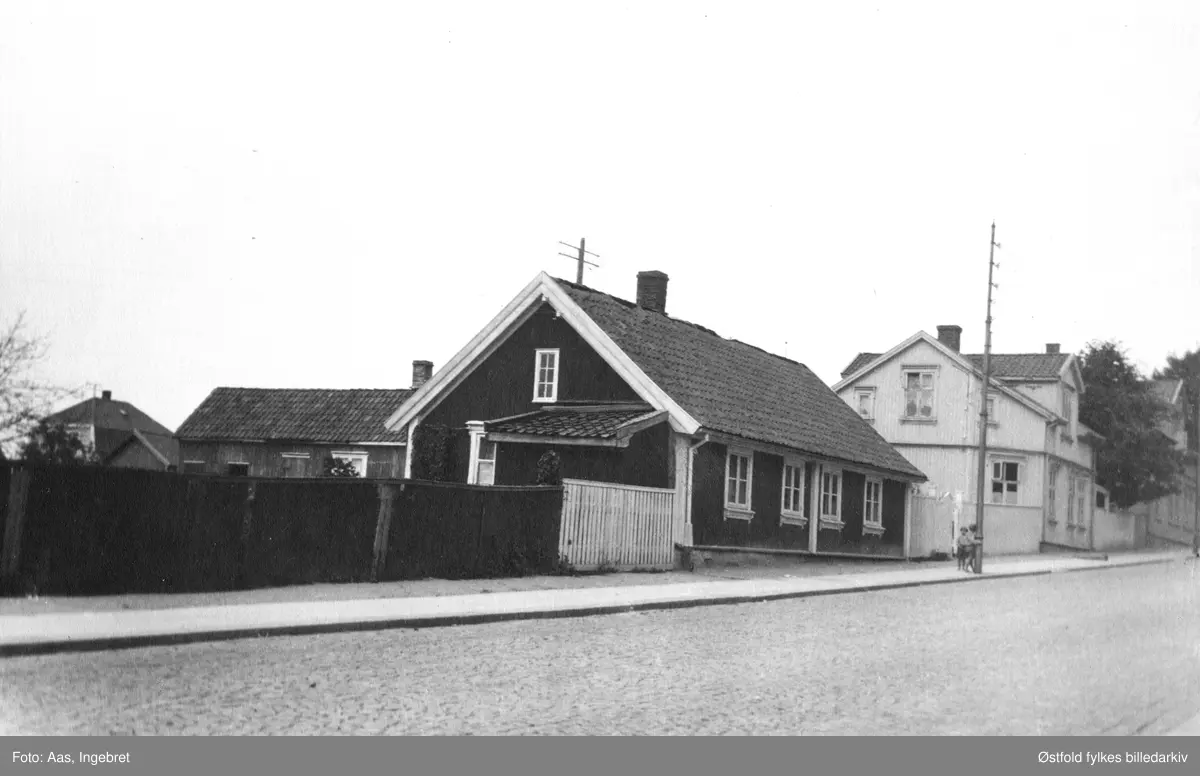 Sandesundsveien (nedre del) fra Sarpsborg i 1927. Det hvite huset ble bygd i 1884, og er Sandesundsveien 59. Huset i mørk farge er revet.