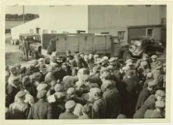 Ei folkemengd framføre ei bygning, i mellomgrunnen står ein 