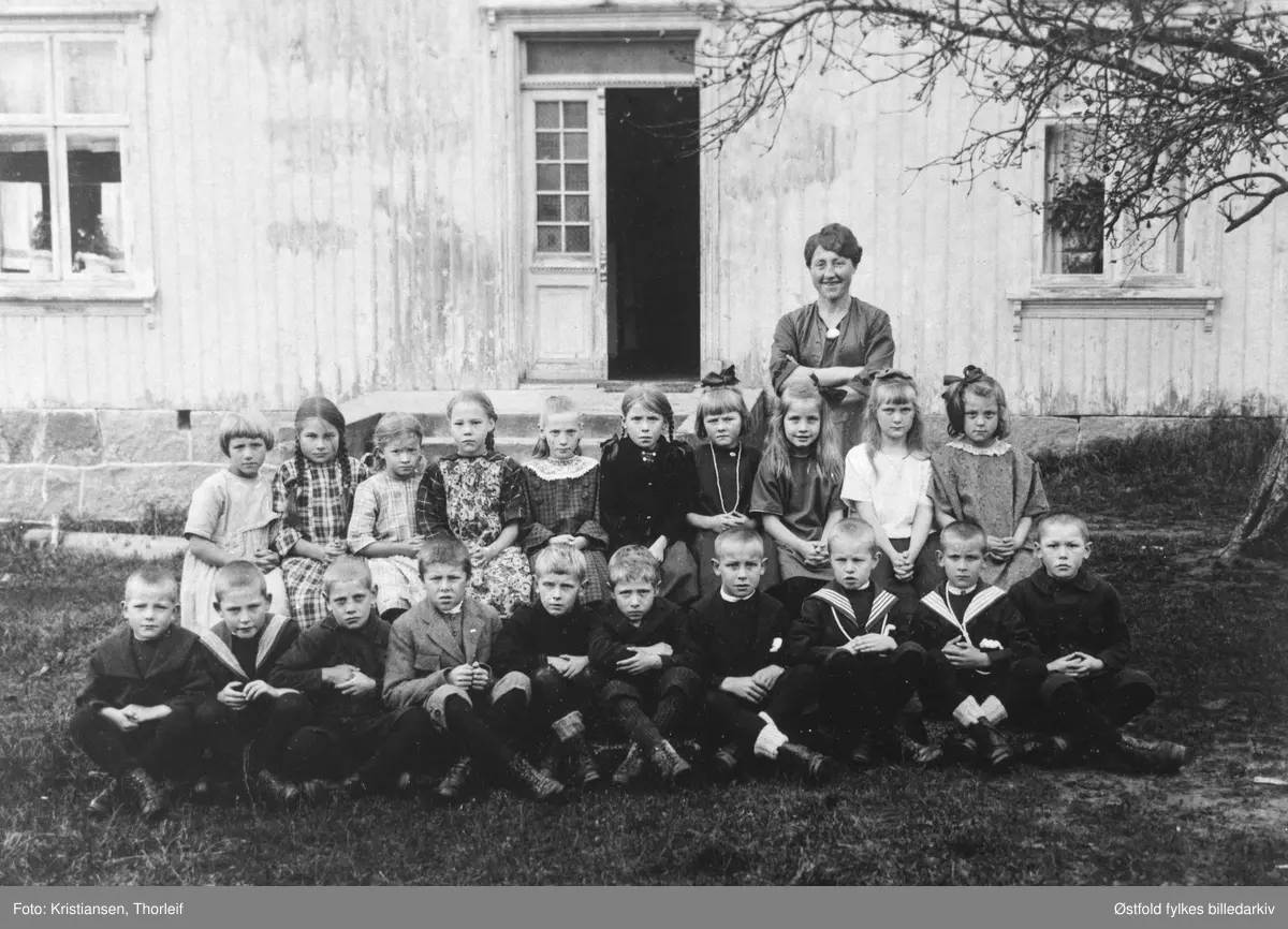 Sikkeland skole (småskolen, 1. og 3.klasse) i Varteig ca. 1924 med lærerinna Aminda Erlandsen. 

Navn med plassering, se fotokort ØFB.1988-00428%.
