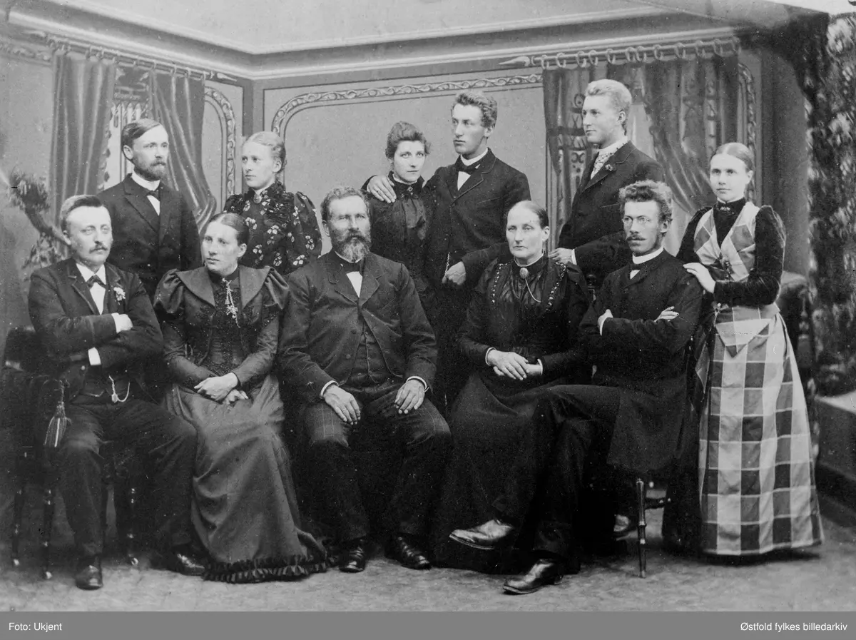 Familien Furuholmen i Varteig ca..1880.
Første rekke fra venstre: 
1. Mathias Skotvedt
2. hans kone Kristine f. Furuholmen 
3. Rikard Furuholmen, ordfører 1883 og bestyrer for lensene 
4. hans kone Oleane Furuholmen 
5. Gunerius Furuholmen
6, hans kone Sigrid Furuholmen
Andre rekke: 
1. Prest Gustav Jensen gift med 
2. Elise f. Furuholmen 
3. Dagny Furuholmen g. m. 
4. Kristian Furuholmen
5. Godtfred Furuholmen