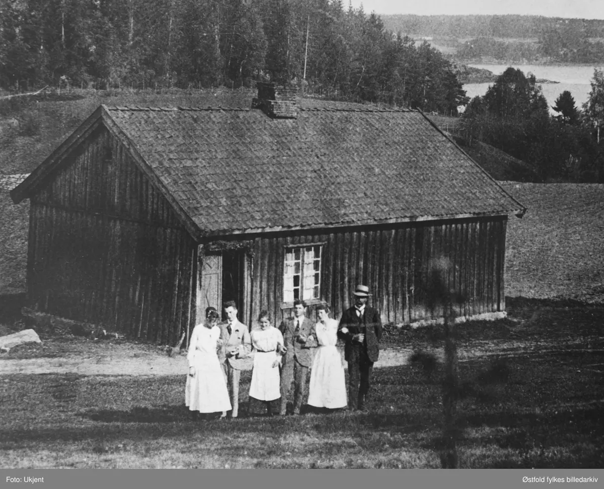 Grøtet ved Vestvannet., Tune Arbeiderbolig med familien oppstilt på utsiden. Vestvannet i bakgrunnen. Andre bilde er utsnitt av gruppen foran huset.