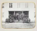 En grupp underofficerare (?) har samlats på trappan till en officersmäss. 1870-tal.
Okänt regemente, okänd ort.