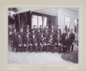En grupp officerare (och regementspastorn) har samlats vid en officersmäss (?). 1890-tal.