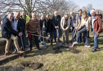 En rekke mennesker står klare med spader i hendene for å ta første spadestikk til Regionalt Historisenter.