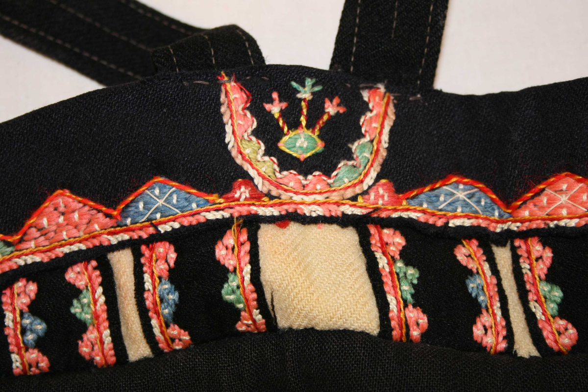 Kvit vadmålsstakk med selar og broderi.