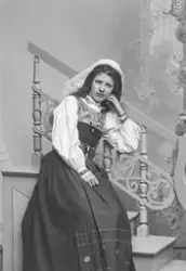 Porträtt av fotograf Ester Läckgren i folkdräkt. Sittande.
T