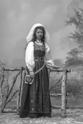 Porträtt av fotograf Ester Läckgren i folkdräkt.
Text baksid