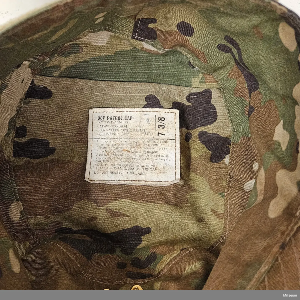 Fältmössa av textil med gradbeteckning av metall.