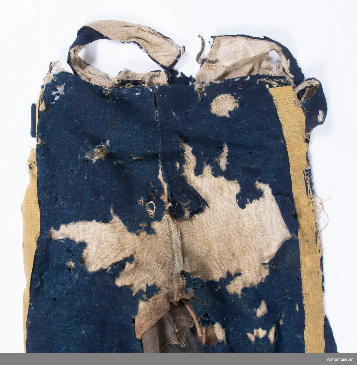 Blå ridbyxor med gula revärer och skinnskodda ben och byxbak.

Byxorna är sydda av ett ganska tunt blått kommisskläde, och är helfodrade med oblekt linne- eller hampalärft.
Modellen är konstruerad med två fram- och två bakstycken, och har hel lucka fram som har knäppts mot en gördel eller linning. Luckan har 5 knapphål fram, varav tre har knäppts mot gördeln. I luckans sidor upptill sitter två spänntampar för knäppning bak i ryggslutet. I sömmen bak sitter en infälld kil för reglering av midjevidden, samt en hank av läder för upphängning.
I sidan har byxorna revärar av 4 cm breda gula redgarnsband.
Byxbenen är skodda med brunt skinn i en höjd av ca 36 cm nertill. Kanten är formad i två bågar fram och en spets bak. Skinnskoningen fortsätter på baksidan upp på insidan av låren och i byxbaken.
Byxorna är mycket trasiga och malätna, och både yttertyg och foder har lagats ett flertal gånger under deras användningstid.
Samtliga knappar saknas förutom i höger byxben längst ner där det sitter rester av enkla skinnknappar i varje sida.

Märkt på insidan "LS No 2".